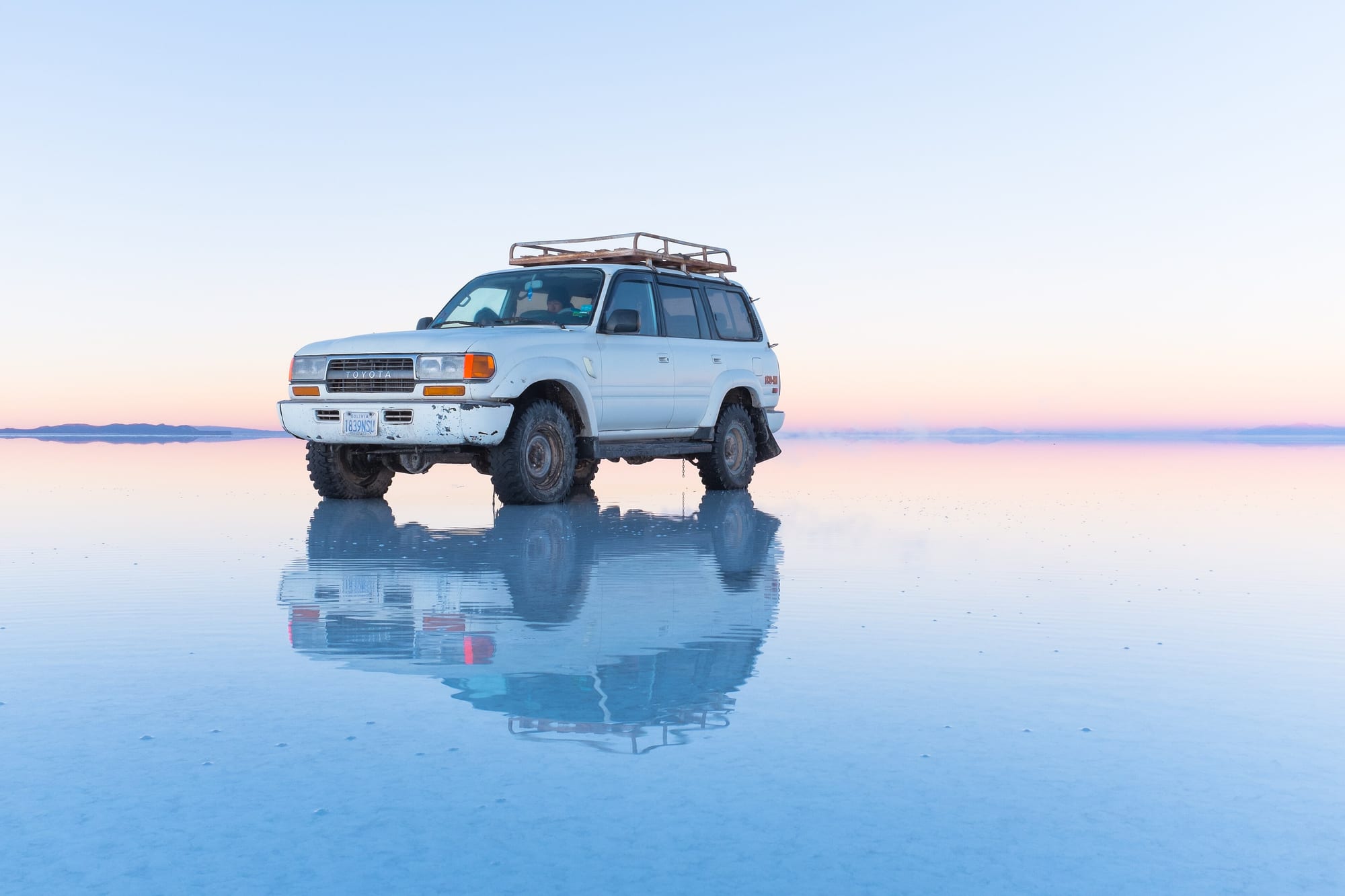 Vehículo reflejado en el espejo de agua del Salar de Uyuni